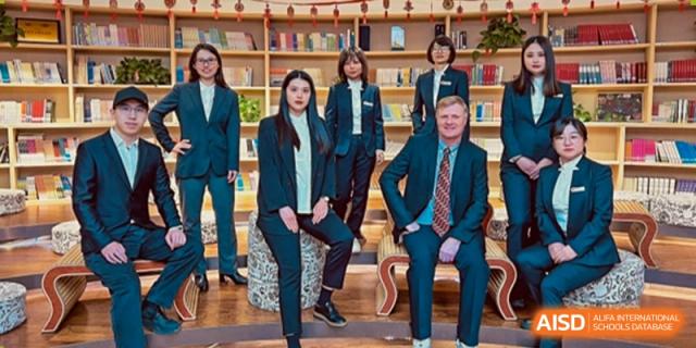A formal portrait of seven school staff members, including a foreign male, posing in professional attire at Yinghua Academy of Tianjin.