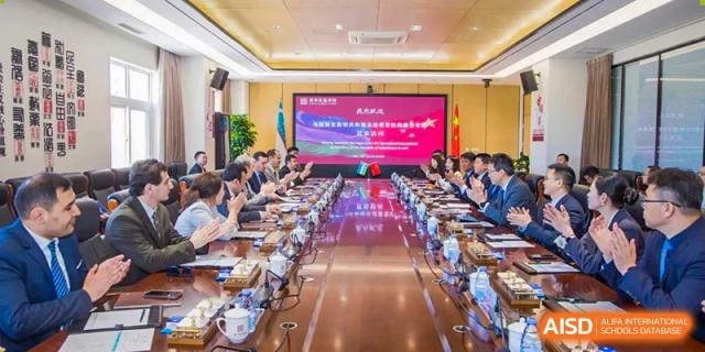 A long, well-attended meeting or class is in session in a large room with a presentation screen at the end at Yinghua Academy of Tianjin.