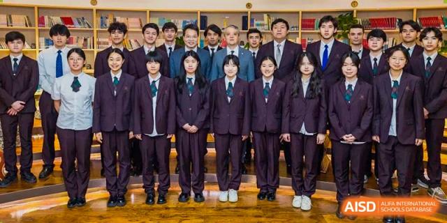 A formal group photo of school staff members and students standing together, all wearing their uniforms at Yinghua Academy of Tianjin.