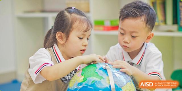 A young female student touches a globe in a classroom, supervised by a male student, at Suzhou Science and Technology Town Foreign Language High School.