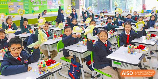 Young students seated at colorful desks and actively participating in a classroom lesson at Suzhou Science and Technology Town Foreign Language High School.