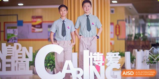 Two male students in matching uniforms posing in front of a colorful backdrop at Suzhou Science and Technology Town Foreign Language High School.