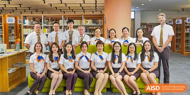 A group of female students and female staff posing while seated together indoors at Suzhou Science and Technology Town Foreign Language High School.