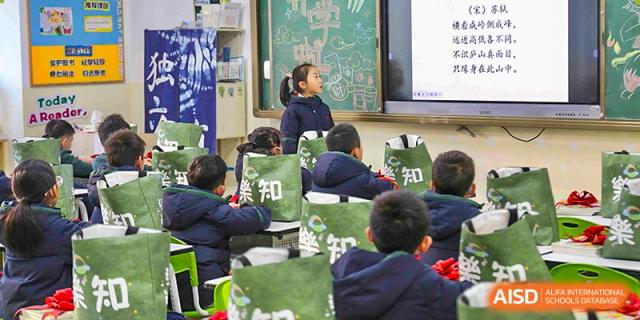 Students in dark uniforms seated at their desks, engaged in a lesson in a classroom at Suzhou Science and Technology Town Foreign Language High School.