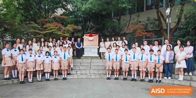 A large group of students and teachers posing for a formal photo outdoors on a set of stairs at Suzhou Science and Technology Town Foreign Language High School.