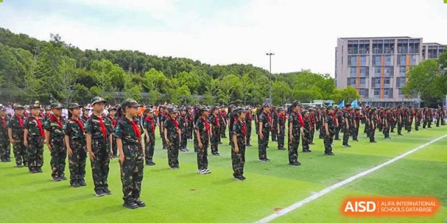 Students in formation during military training on a green field at Suzhou Science and Technology Town Foreign Language High School.