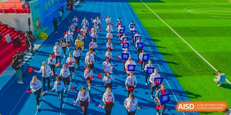 Students in uniform standing in organized rows on a blue sports field during an event at Suzhou Science and Technology Town Foreign Language High School.