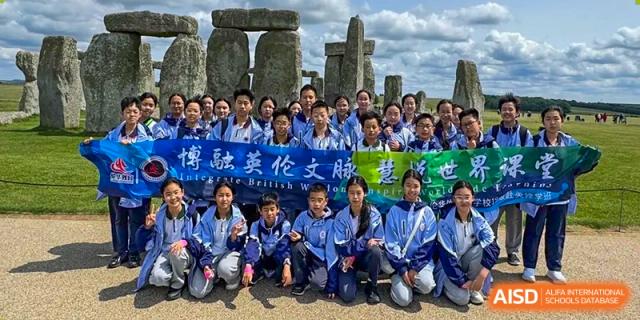 Students posing for a group photo in front of Stonehenge during an international or school trip. Suzhou Science and Technology Town Foreign Language High School.