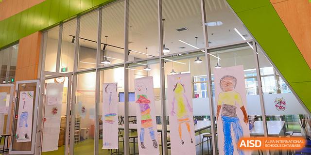 A creative learning space at Dehong Beijing International Chinese School with student artwork and drawings displayed.