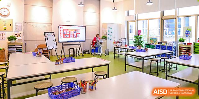 A modern classroom at Dehong Beijing International Chinese School with flexible seating, a smart board, and natural light.