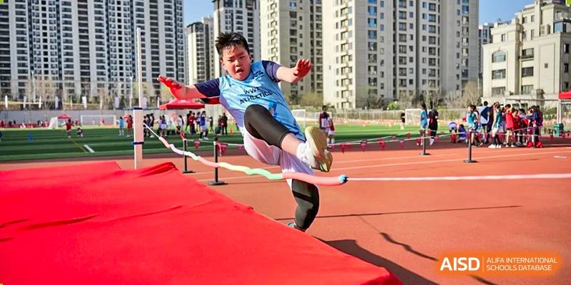 An athlete from Dehong Beijing International Chinese School performing a high jump during a track and field competition.