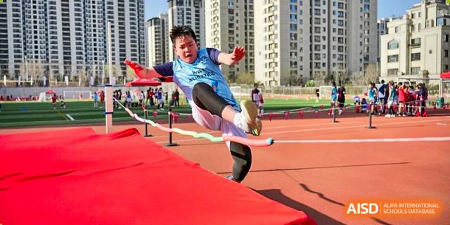 An athlete from Dehong Beijing International Chinese School performing a high jump during a track and field competition.