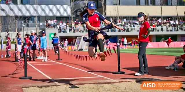 A student athlete from Dehong Beijing International Chinese School performs a long jump during a track and field competition.