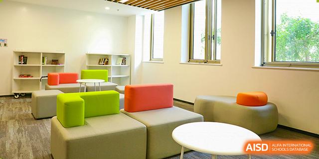 A comfortable common room or lounge area at Dehong Beijing International Chinese School with modern, colourful seating.