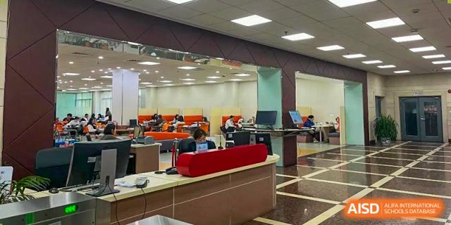 Students are studying or working on laptops in a spacious, modern study area with partitions at Cambridge International School Litai College. SISU.