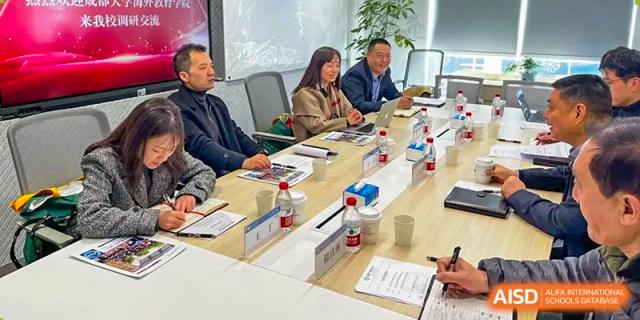Three professionals, two men and one woman, sit around a conference table during a formal meeting at Cambridge International School Litai College. SISU.