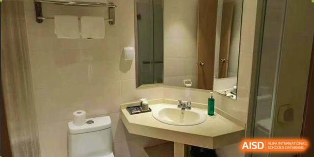 A well-lit, clean bathroom with a sink, mirror, and toilet visible at Cambridge International School Litai College. SISU.