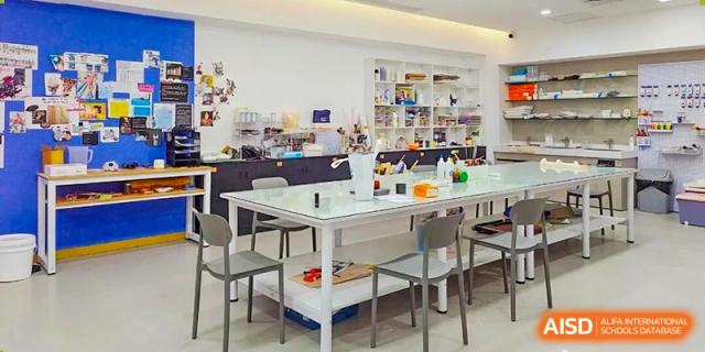 A bright, modern maker space featuring a large central project table and shelves full of supplies at Shenzhen Academy of International Education.