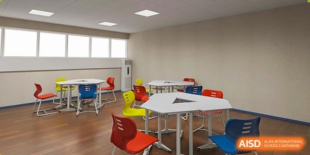 A bright and modern empty classroom featuring innovative white modular desks and colorful chairs in red, blue, and yellow at Shenzhen Academy of International Education.