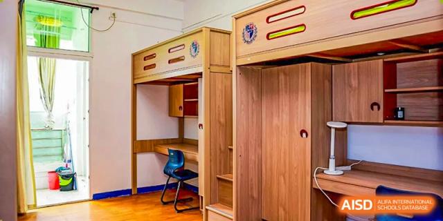 A modern dormitory room featuring a loft bed with a built-in desk and wardrobe at the Shenzhen Academy of International Education.