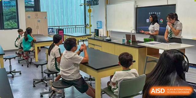 Students sitting at a laboratory desk and engaging in a hands-on science lesson within a modern classroom at Shen Wai International School.