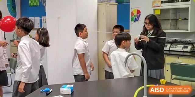 Students observe a string-based science experiment during a practical learning session in the lab at Shen Wai International School.