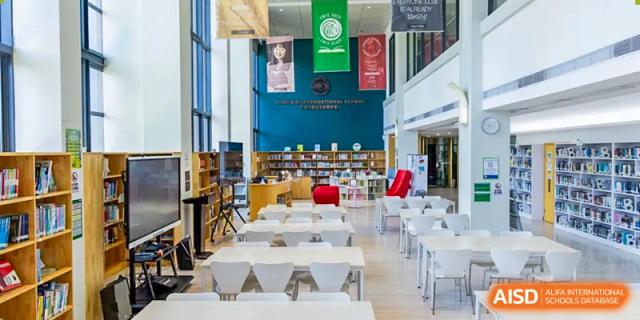 A wide view of the bright, modern school library featuring study tables, colorful banners, and bookshelves at Shen Wai International School.