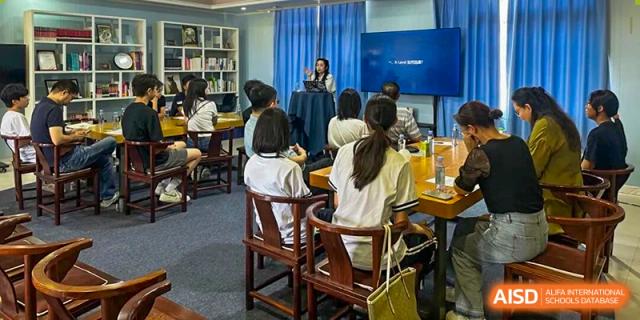 A teacher stands at the front of a classroom using a digital screen to present a lesson to attentive students at Zhongshan Sanxin School International Department.