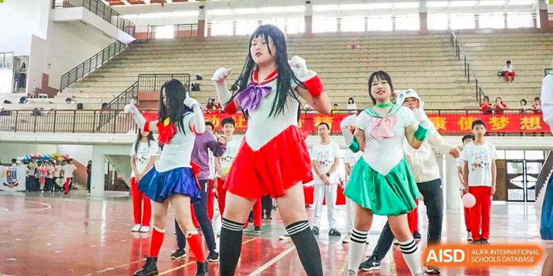 Students perform a choreographed dance on stage while dressed in colorful anime-inspired Sailor Moon costumes at Zhongshan Sanxin School International Department.