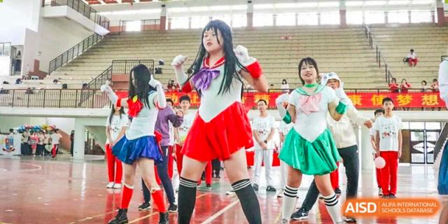Students perform a choreographed dance on stage while dressed in colorful anime-inspired Sailor Moon costumes at Zhongshan Sanxin School International Department.