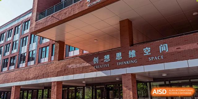 The exterior of a brick building features large characters for the "Creative Thinking Space" above the entrance to a specialized learning facility at Beijing Chaoyang KaiWen Academy.