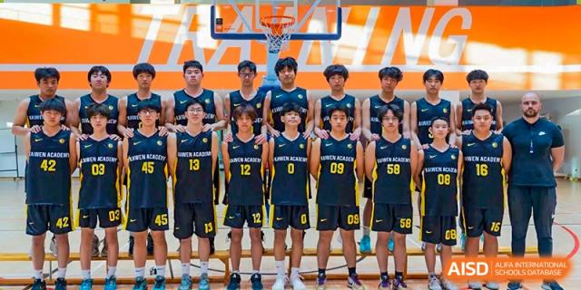A male youth basketball team in black and yellow uniforms stands in a line on a court in front of a large "TRAINING" banner for a commemorative photo at Beijing Chaoyang KaiWen Academy.