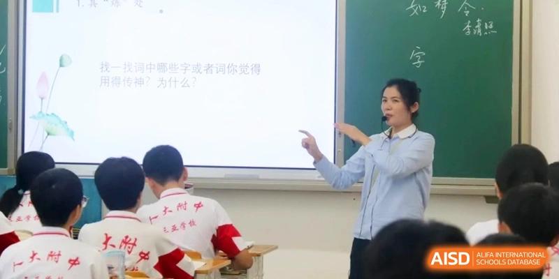 A teacher points toward a digital whiteboard during a lecture to engage her students in a classroom discussion at RDFZ Sanya School