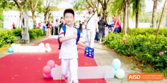 A young student walks confidently along a decorated path during an outdoor celebration or open house at RDFZ Sanya School