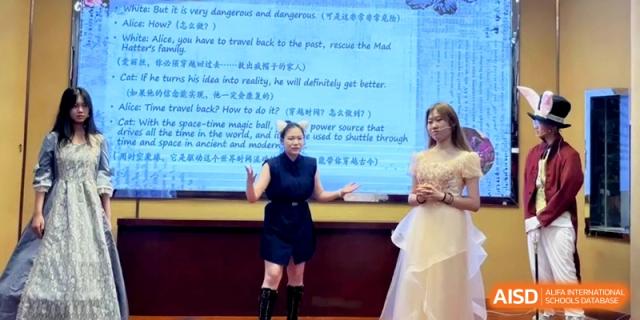 Two students perform a presentation or skit on stage in front of a digital screen at the Attached Senior School Of Shandong Normal University.