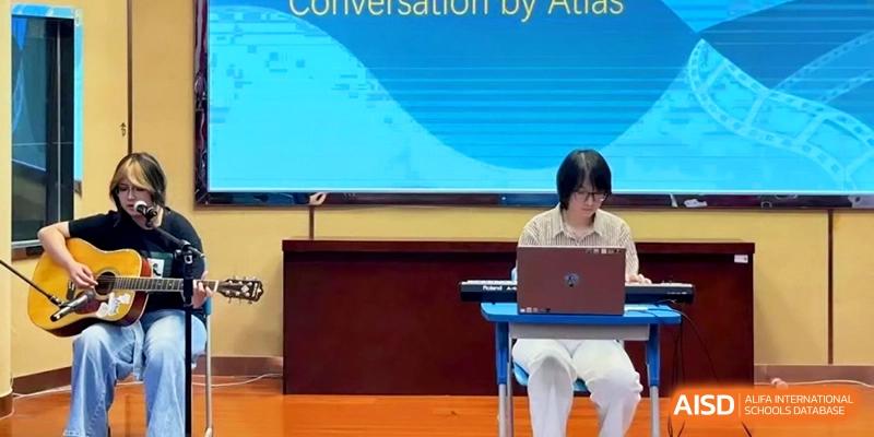 A student performs on a keyboard and laptop during a "Conversation By Atlas" event at the Attached Senior School Of Shandong Normal University.