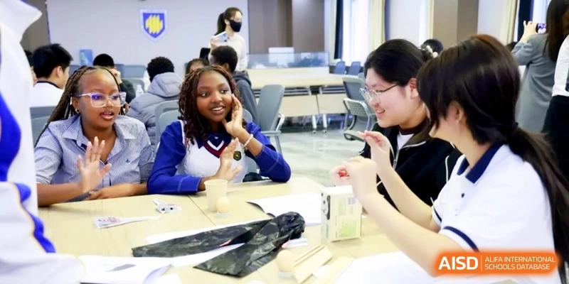 Two students engage in a collaborative hands-on activity at a desk during class at the Attached Senior School Of Shandong Normal University.