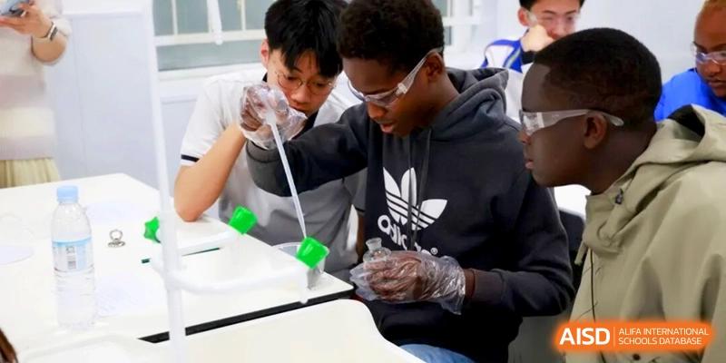 Students wearing safety gloves use a pipette to conduct a science experiment at the Attached Senior School Of Shandong Normal University.
