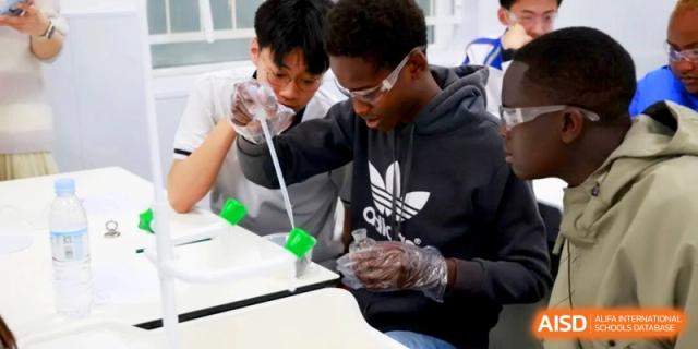 Students wearing safety gloves use a pipette to conduct a science experiment at the Attached Senior School Of Shandong Normal University.