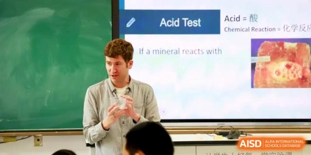 A teacher explains a lesson on "Acid Test" using a digital whiteboard in a classroom at the Attached Senior School Of Shandong Normal University.
