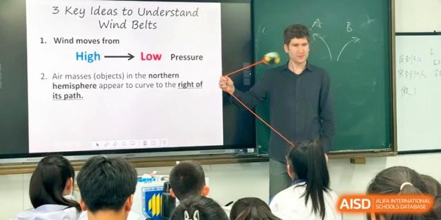 An instructor points to a diagram on a screen during a geography lesson at the Attached Senior School Of Shandong Normal University.