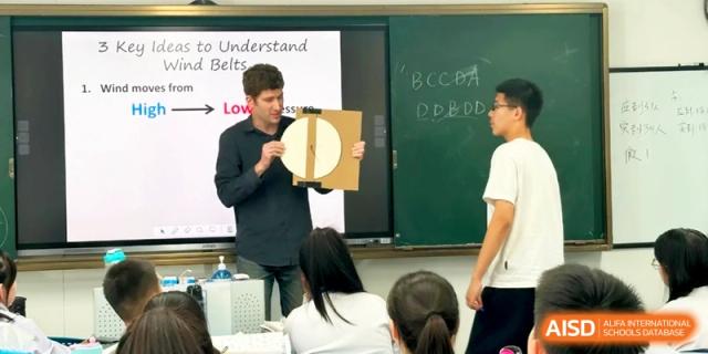 A teacher uses a physical model to explain wind belts and pressure to students at the Attached Senior School Of Shandong Normal University.