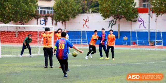 Football players in mismatched jerseys compete during a lively soccer match at the Attached Senior School Of Shandong Normal University.