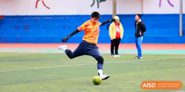 A student athlete prepares to kick the soccer ball during a high-energy match at the Attached Senior School Of Shandong Normal University.