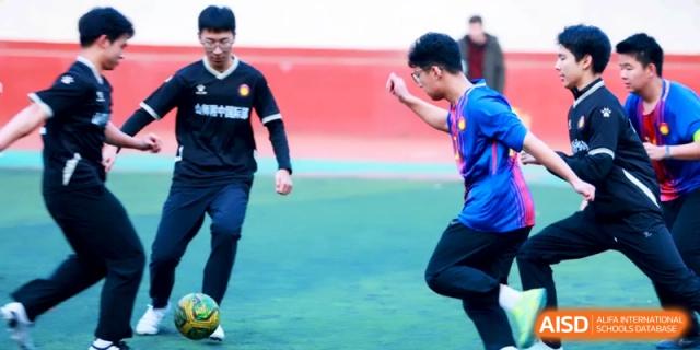 Two soccer players face off during a practice session on the outdoor turf at the Attached Senior School Of Shandong Normal University.