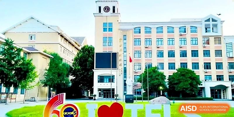 View of the modern academic building and campus clock tower under a clear blue sky at Tianjin Foreign Languages School.