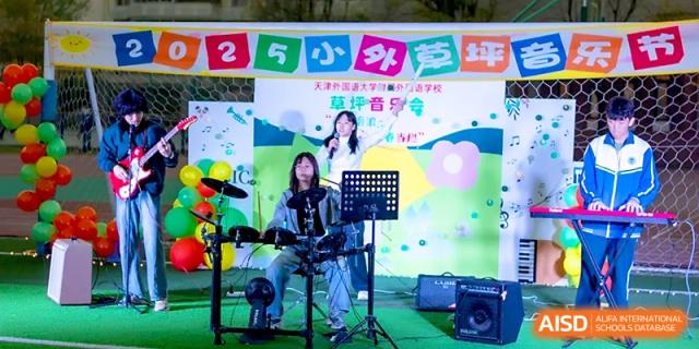 A student drummer plays an electronic drum kit during a lively outdoor concert on the campus grounds at Tianjin Foreign Languages School.