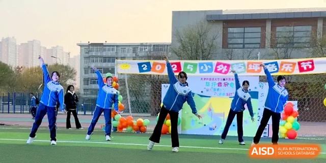 Dancers in blue and white school jackets perform a choreographed routine on the outdoor turf at Tianjin Foreign Languages School.