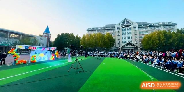 A wide view of the school's expansive green field set up for a major outdoor event or festival at Tianjin Foreign Languages School.
