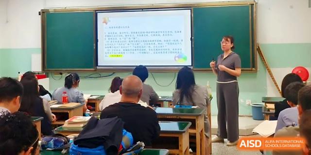 A teacher presents a digital lesson on a large screen to a classroom of attentive students at Urumqi Bayi High School.